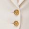 Close-up of AURA ivory cropped tailored jacket featuring sculpted lapels and polished gold statement buttons by Modella