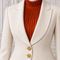 Close-up of the AURA women’s ivory three-piece tailored suit by Modella showing the structured ivory jacket, gold buttons and orange pleated high-neck blouse
