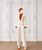 Front view of AURA women’s ivory three-piece tailored suit by Modella with orange pleated blouse and wide-leg trousers