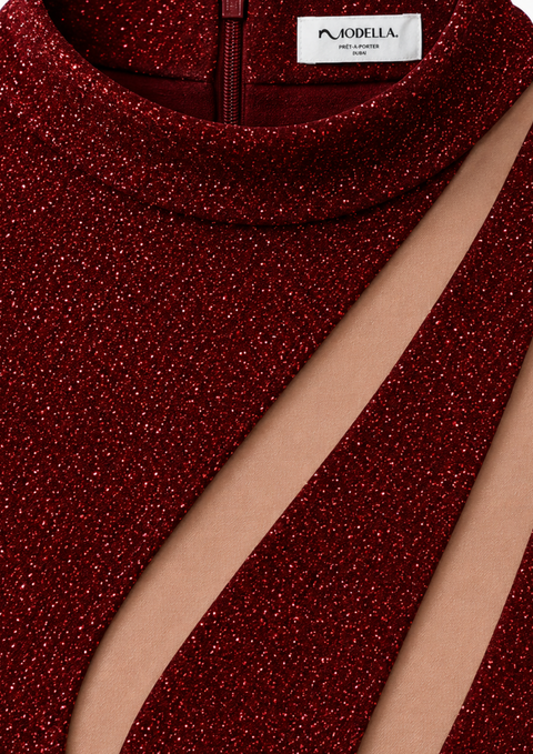 Close-up of LILIA red glitter dress by Modella showing the shimmering fabric, cutout detailing and Modella garment label