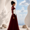 Side view of NYRA burgundy evening gown by Modella showcasing layered tulle volume and sculpted bodice construction