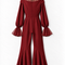 Back view of the VERA burgundy high-low jumpsuit by Modella featuring a sheer pleated high-neck yoke, fitted waist, long sleeves with sheer flared cuffs and dramatic high-low flared legs
