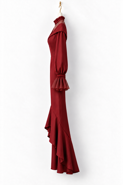 Side view of the VERA burgundy high-low jumpsuit by Modella featuring a fitted waist, sheer high-neck yoke, flared tulle cuffs and dramatic layered high-low legs